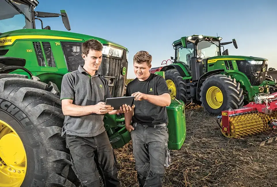 Mitarbeiter im Gespräch vor Treckern
