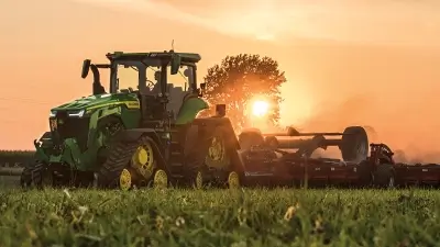 Landwirtschaftliches Fahrzeug bei Sonnenaufgang auf Feld