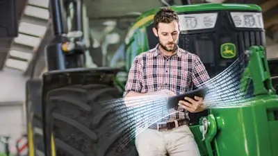 Mitarbeiter mit Tablet vor John Deere Trecker