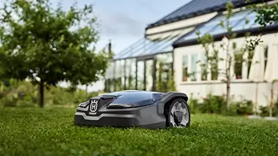 Elektrischer Rasenmäher vor Wohnhaus