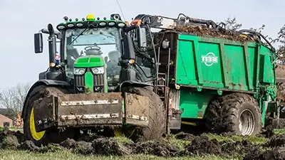 Traktor mit Anhänger mit Grünabfällen