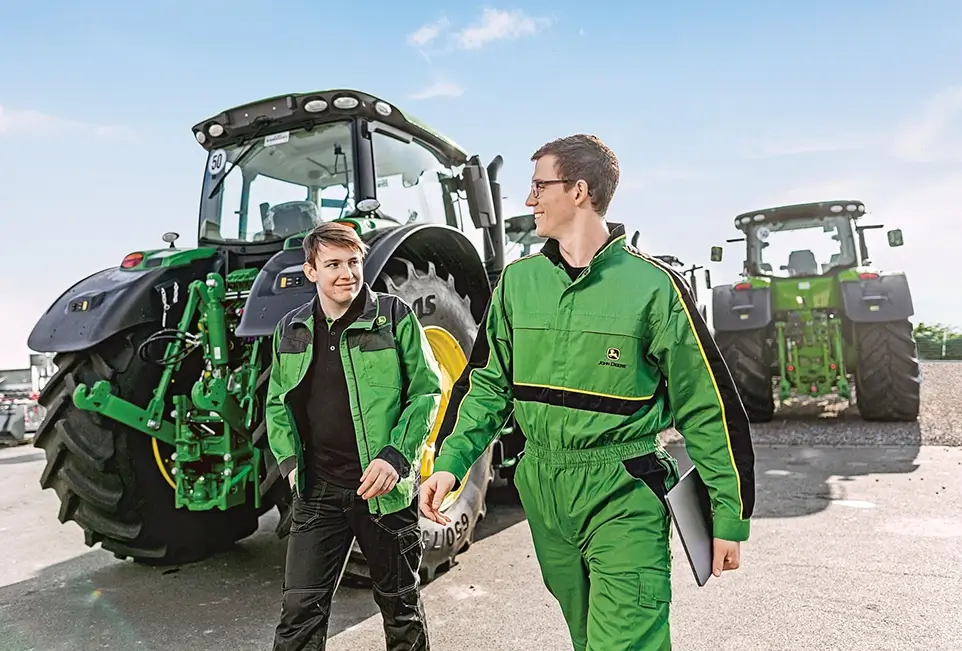 Mitarbeiter im Gespräch vor Treckern
